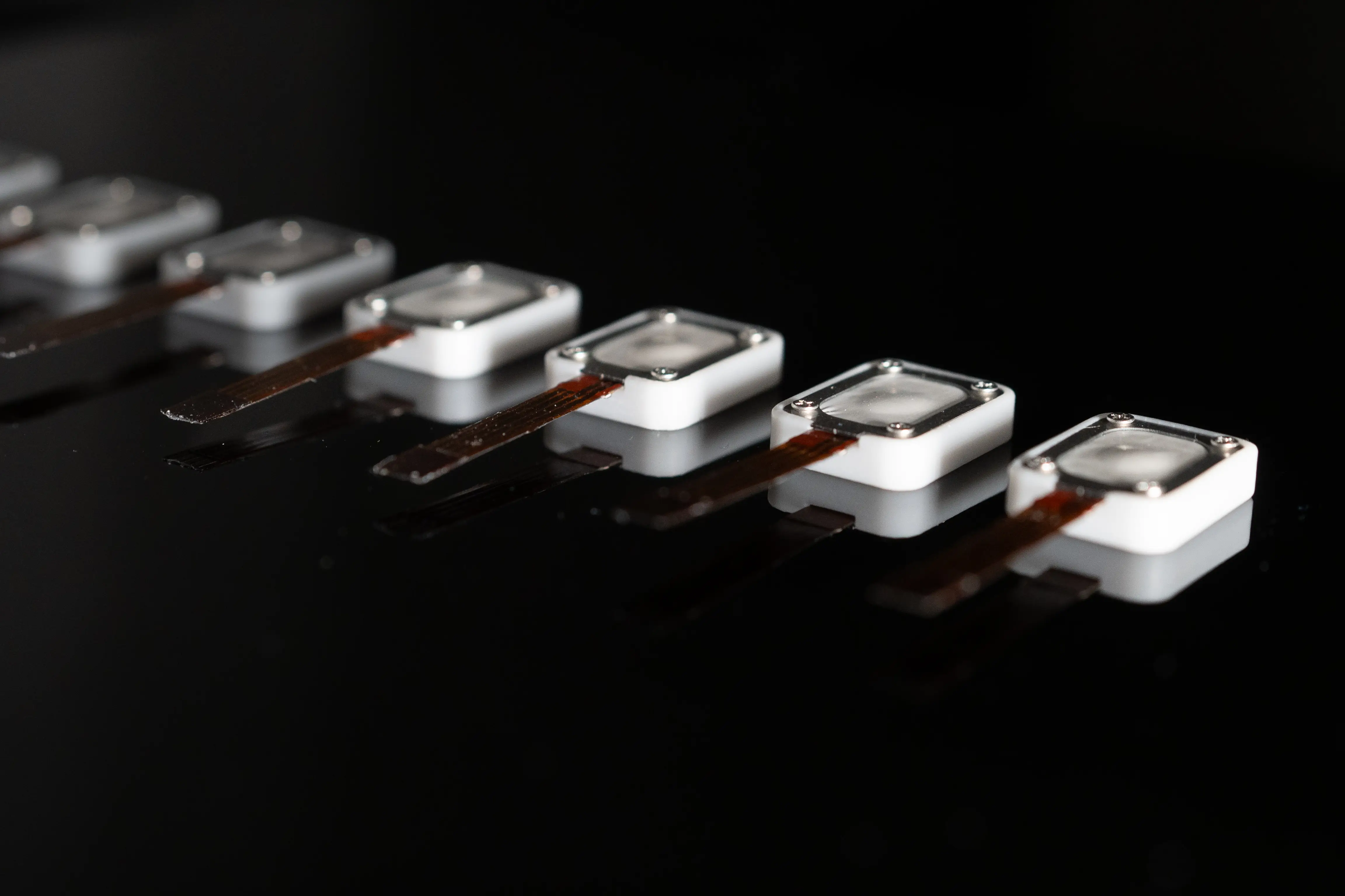 Row of electroosmotic haptic actuators on black glass